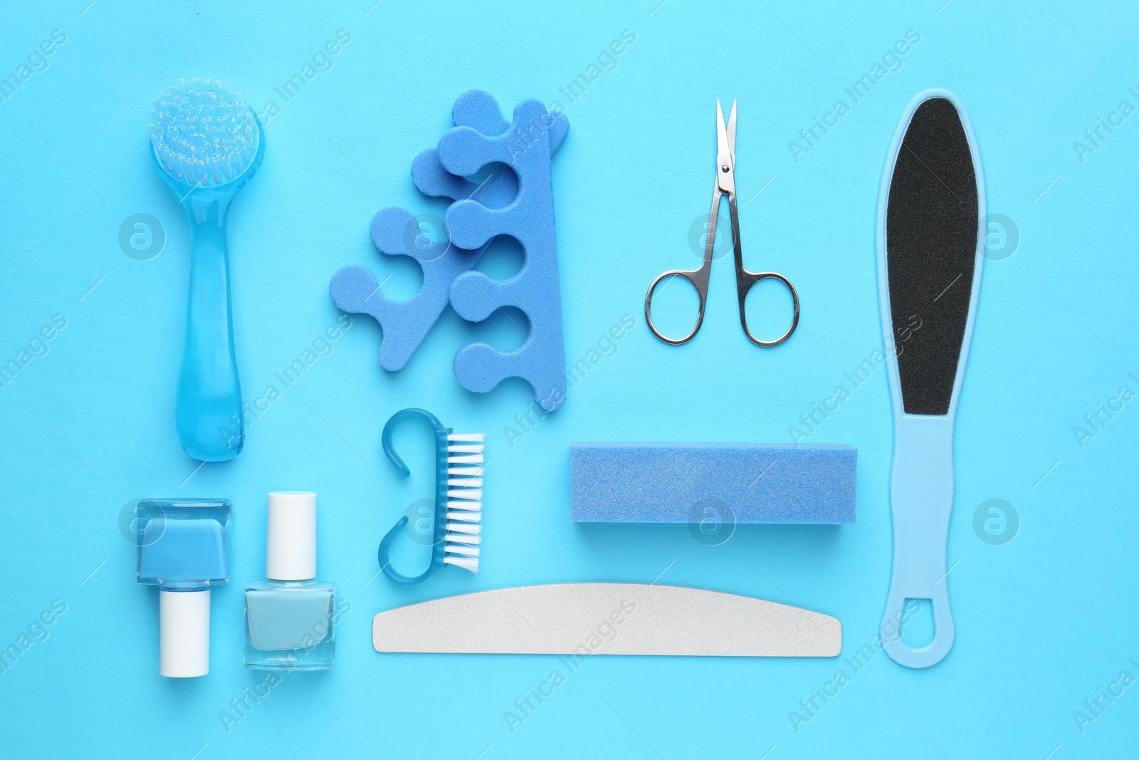 Photo of Set of pedicure tools on light blue background, flat lay