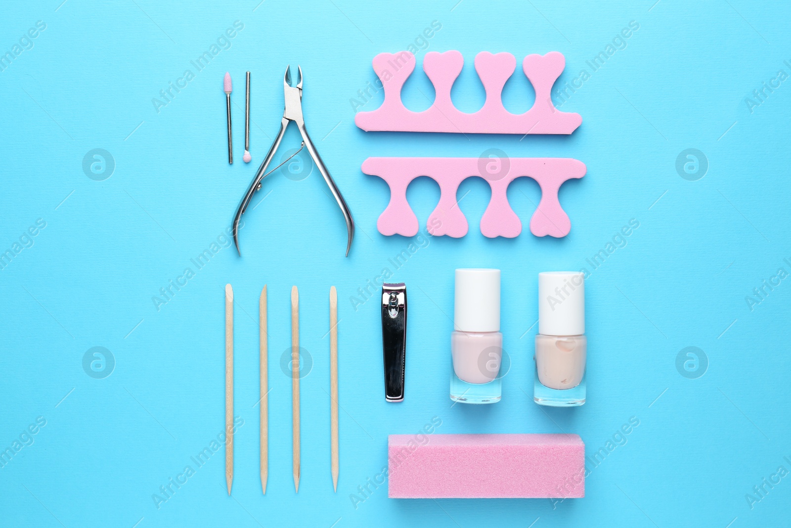 Photo of Set of pedicure tools on light blue background, flat lay