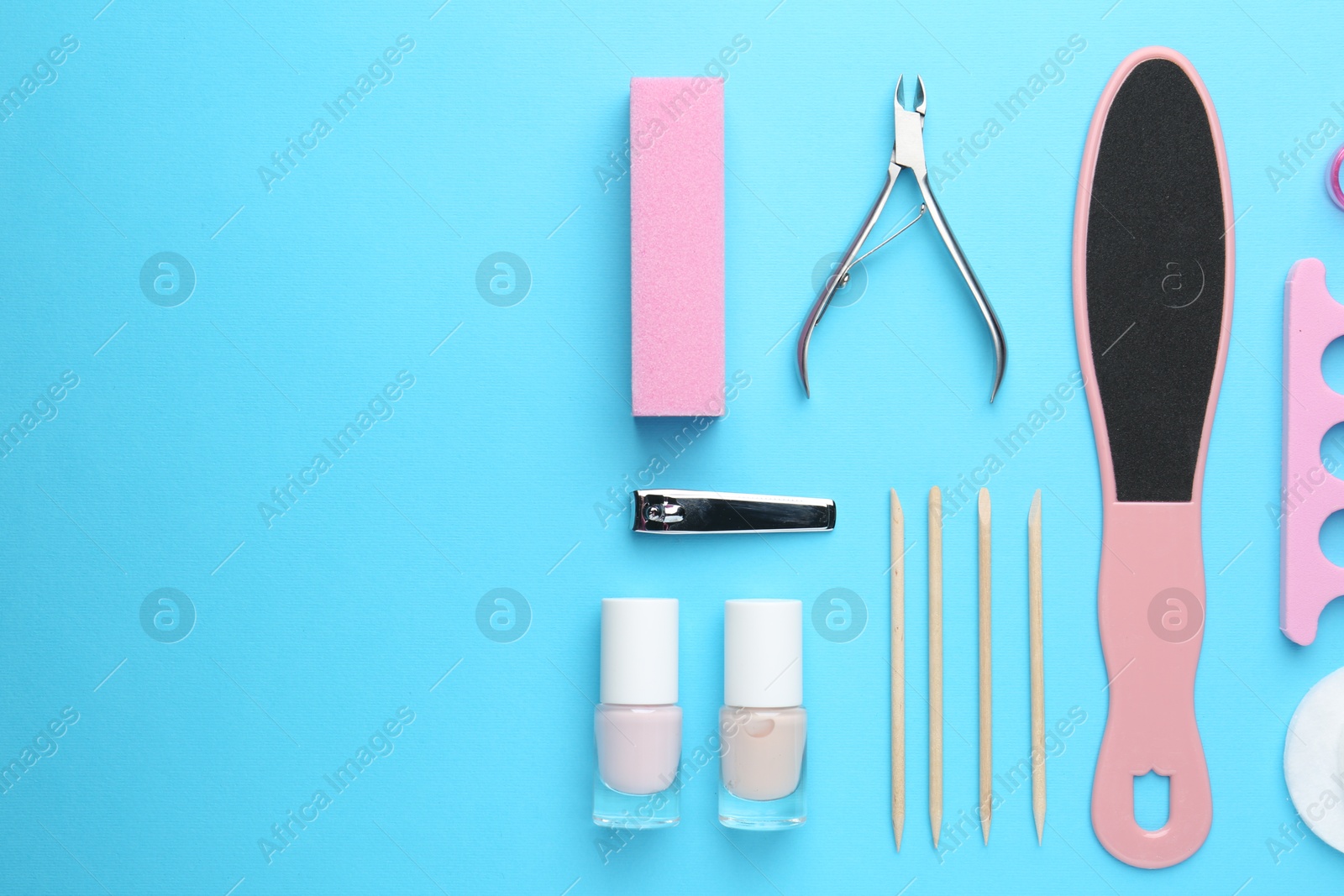 Photo of Set of pedicure tools on light blue background, flat lay. Space for text