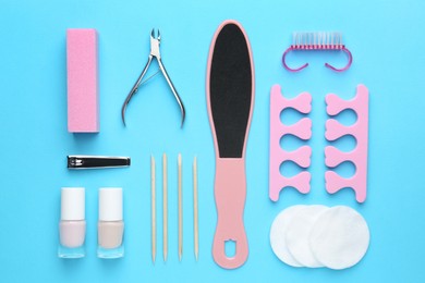 Photo of Set of pedicure tools on light blue background, flat lay