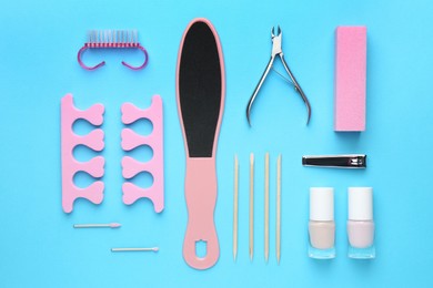 Photo of Set of pedicure tools on light blue background, flat lay