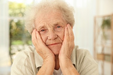 Photo of Portrait of beautiful senior woman against blurred background