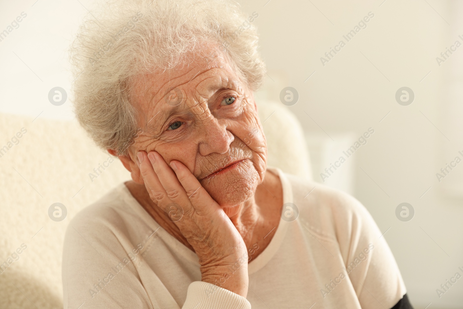 Photo of Portrait of pensive senior woman at home