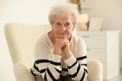 Photo of Beautiful senior woman sitting on armchair at home