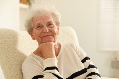 Photo of Beautiful senior woman sitting on armchair at home