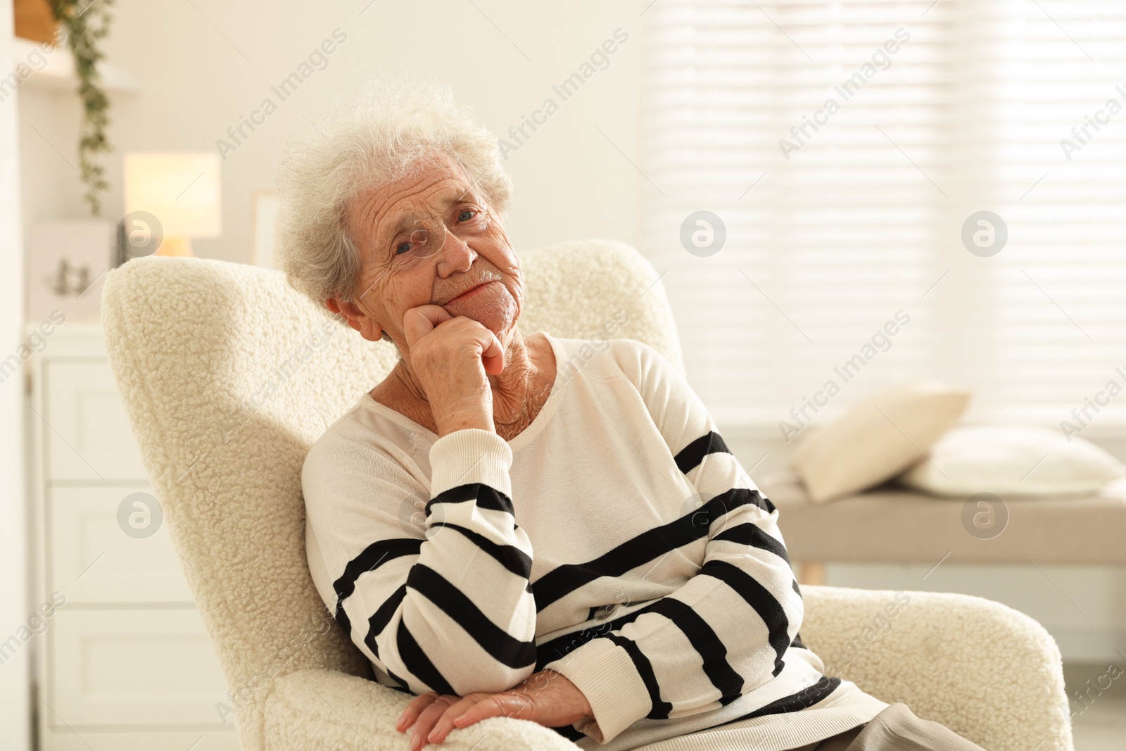 Photo of Beautiful senior woman sitting on armchair at home