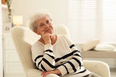 Photo of Beautiful senior woman sitting on armchair at home