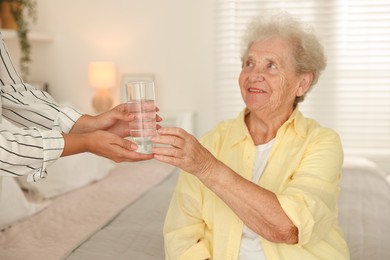 Photo of Senior woman getting glass of water indoors