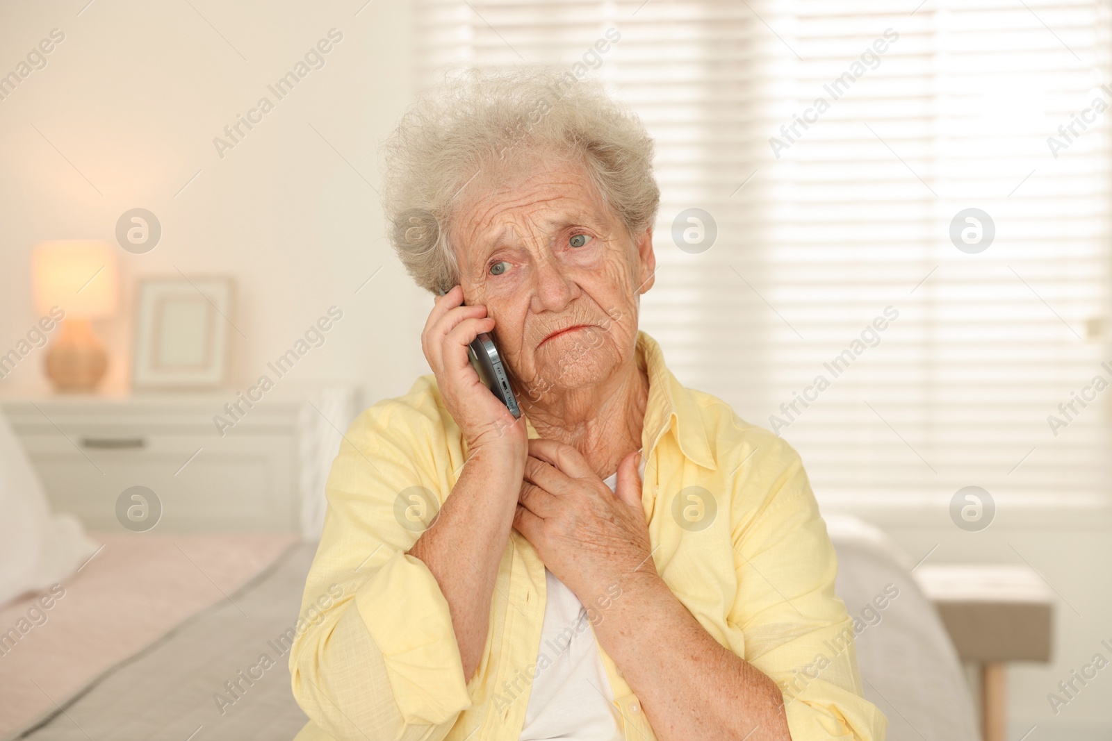 Photo of Senior woman talking on smartphone at home