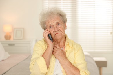 Photo of Senior woman talking on smartphone at home