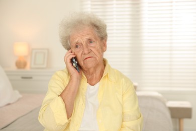 Photo of Senior woman talking on smartphone at home