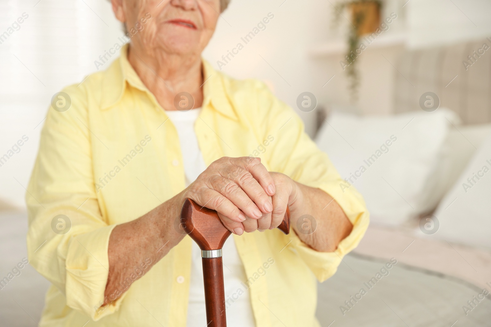 Photo of Senior woman with walking cane indoors, closeup