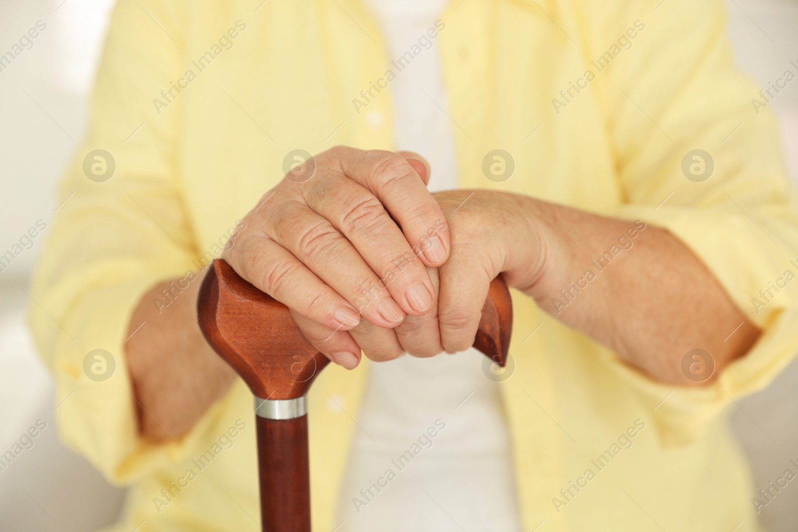 Photo of Senior woman with walking cane indoors, closeup