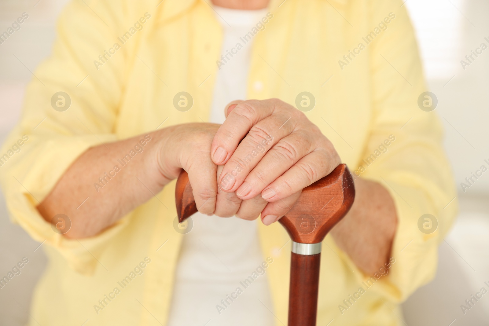 Photo of Senior woman with walking cane indoors, closeup