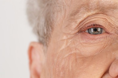 Photo of Senior woman with beautiful eyes on white background, closeup