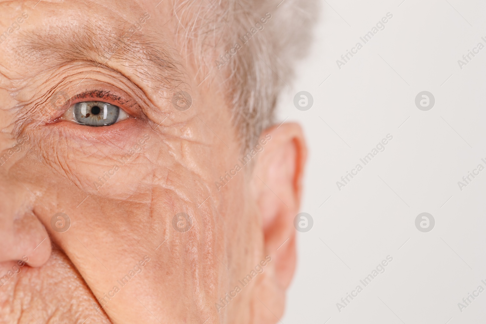 Photo of Senior woman with beautiful eyes on white background, closeup