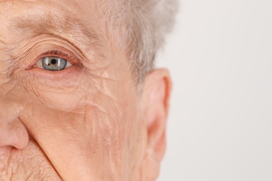 Senior woman with beautiful eyes on white background, closeup