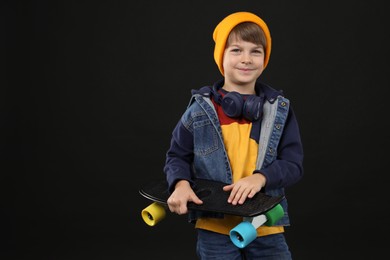 Photo of Little boy with skateboard on black background