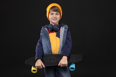 Photo of Little boy with skateboard on black background