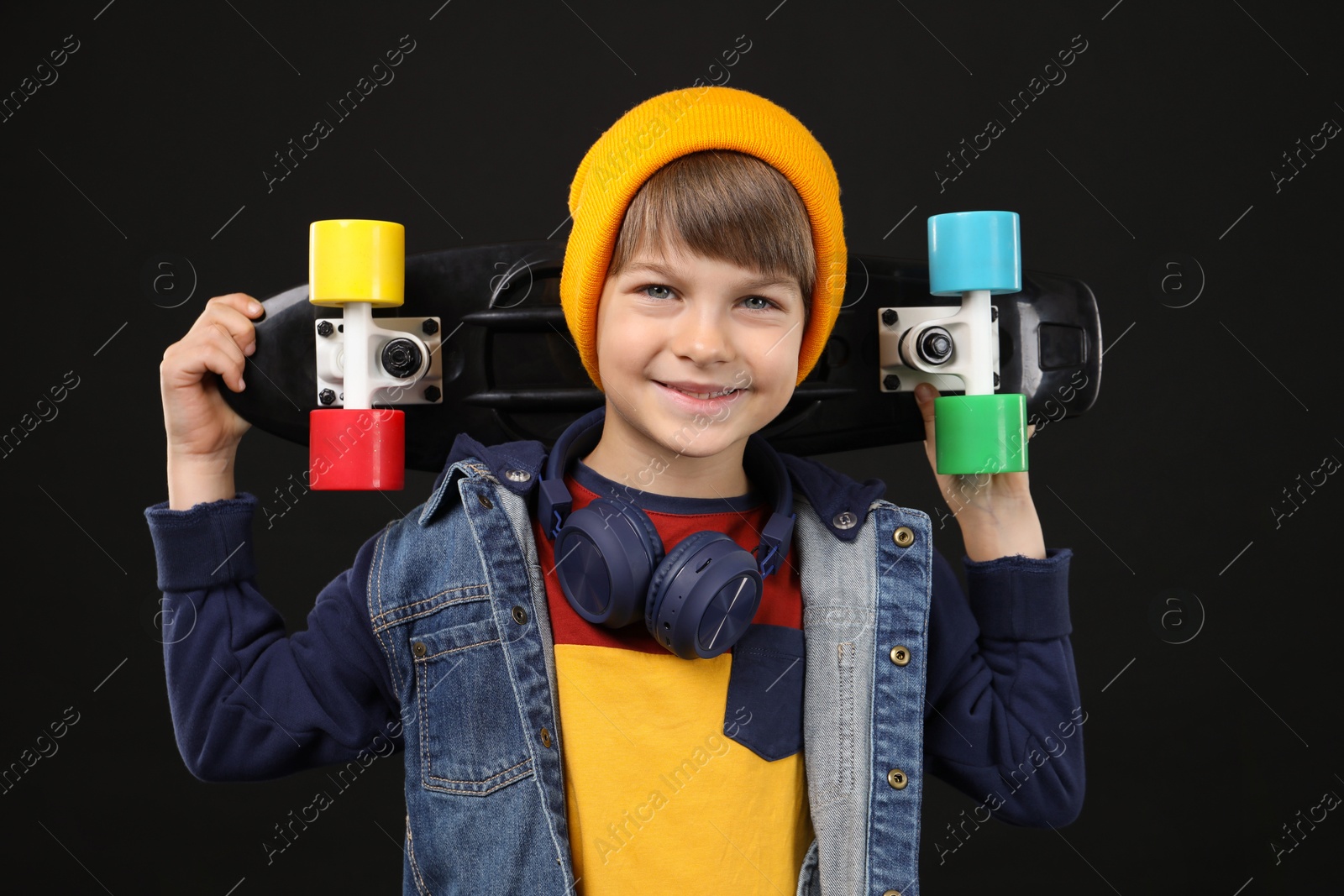 Photo of Little boy with skateboard on black background