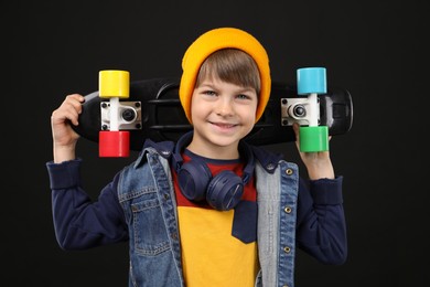 Photo of Little boy with skateboard on black background