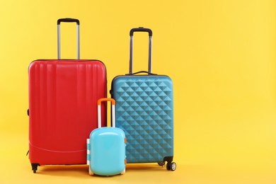 Photo of Different packed suitcases on yellow background. Travel luggage