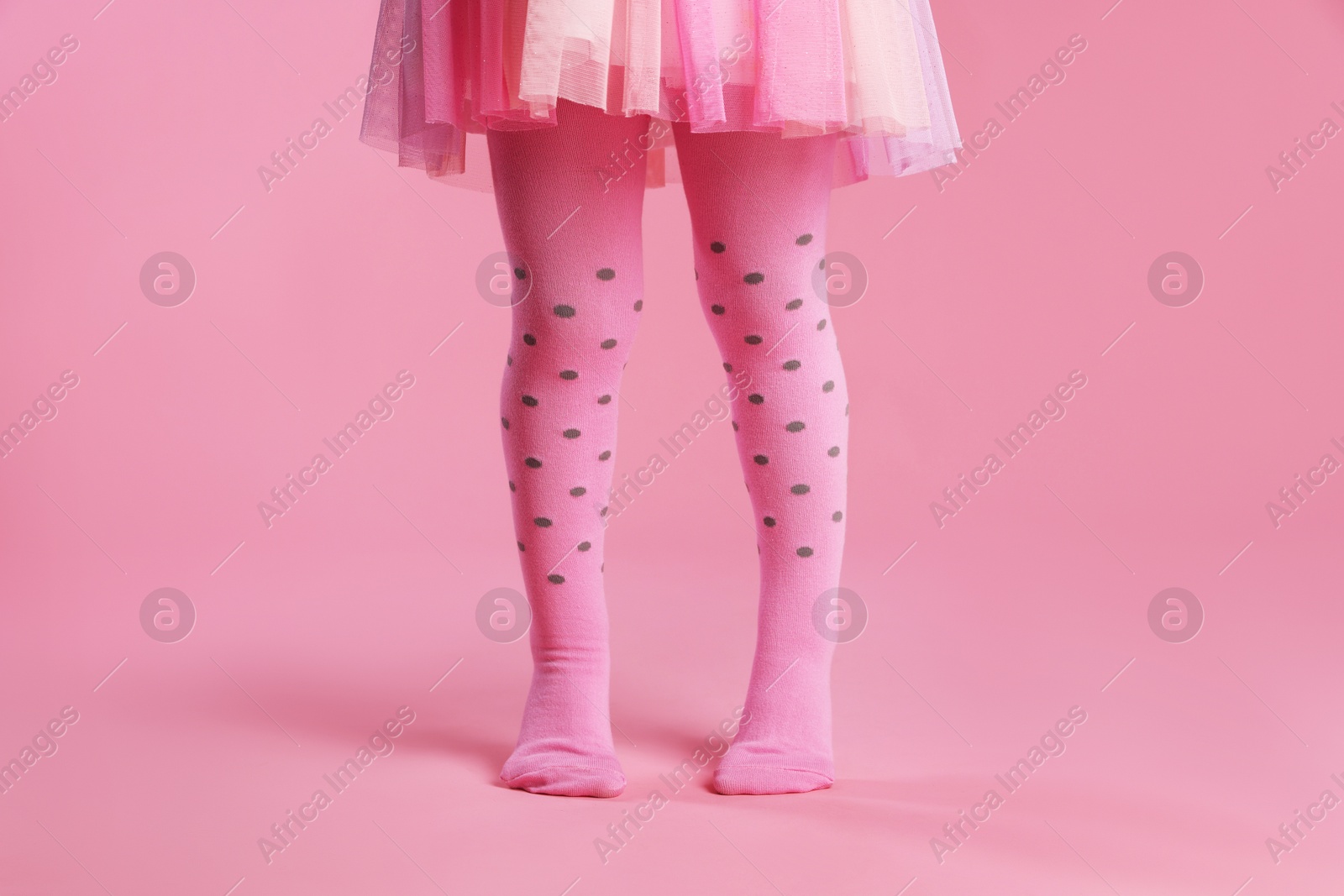 Photo of Child wearing tights on pink background, closeup