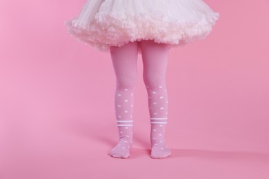 Photo of Child wearing tights on pink background, closeup