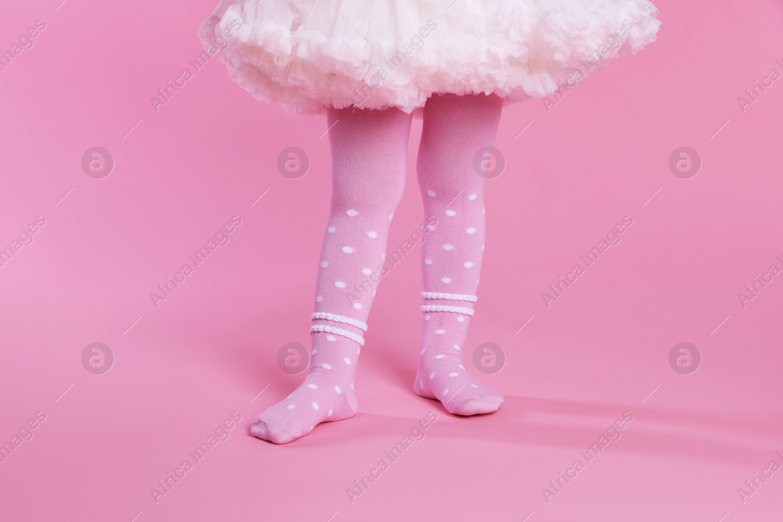 Photo of Child wearing tights on pink background, closeup