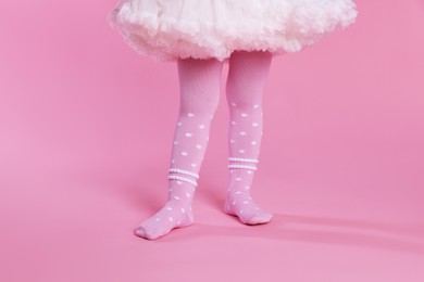 Photo of Child wearing tights on pink background, closeup