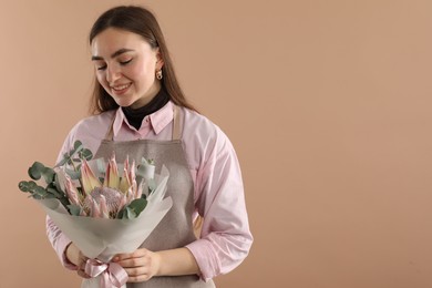 Photo of Florist with beautiful bouquet on beige background. Space for text