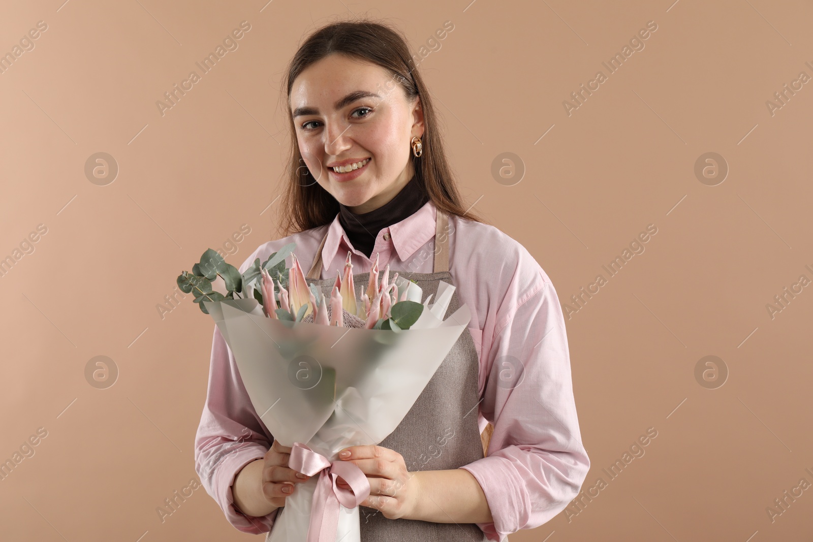 Photo of Florist with beautiful bouquet on beige background