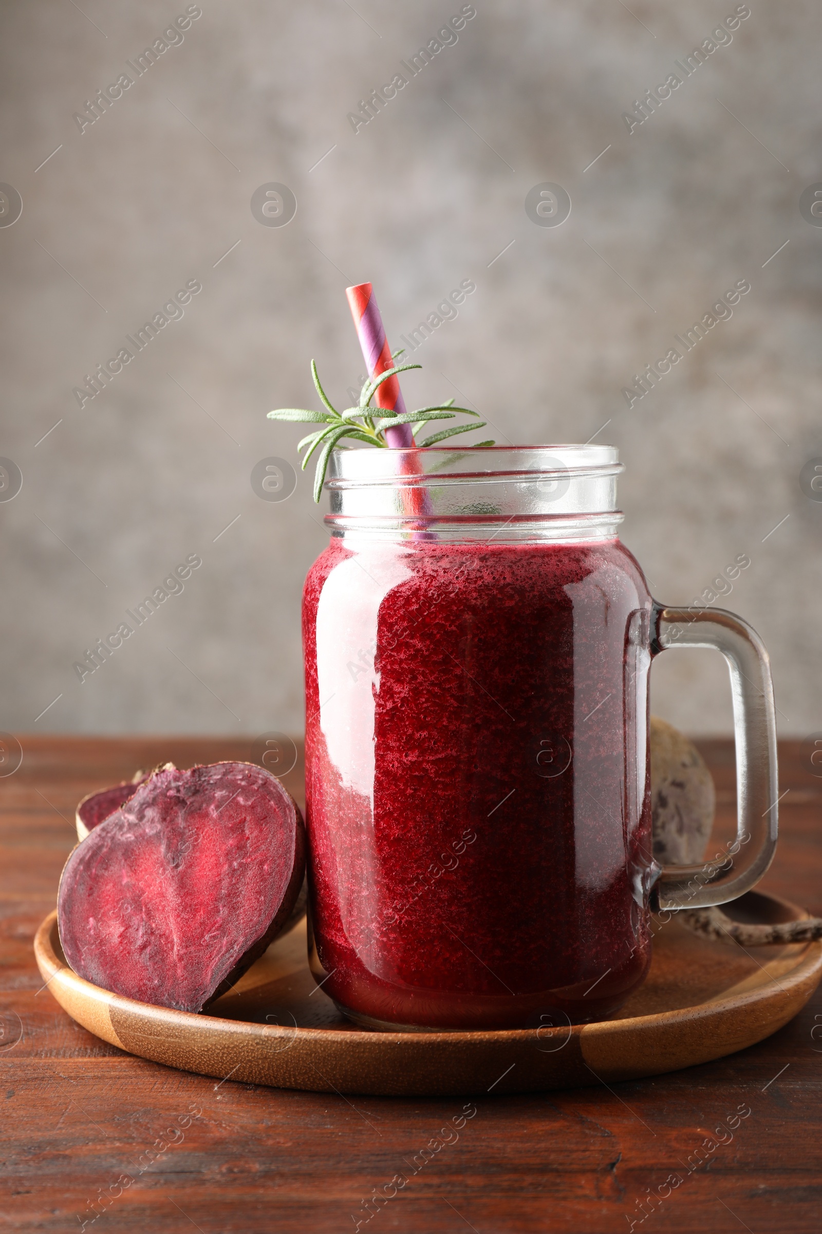 Photo of Fresh beetroot smoothie in mason jar and vegetables on wooden table, closeup