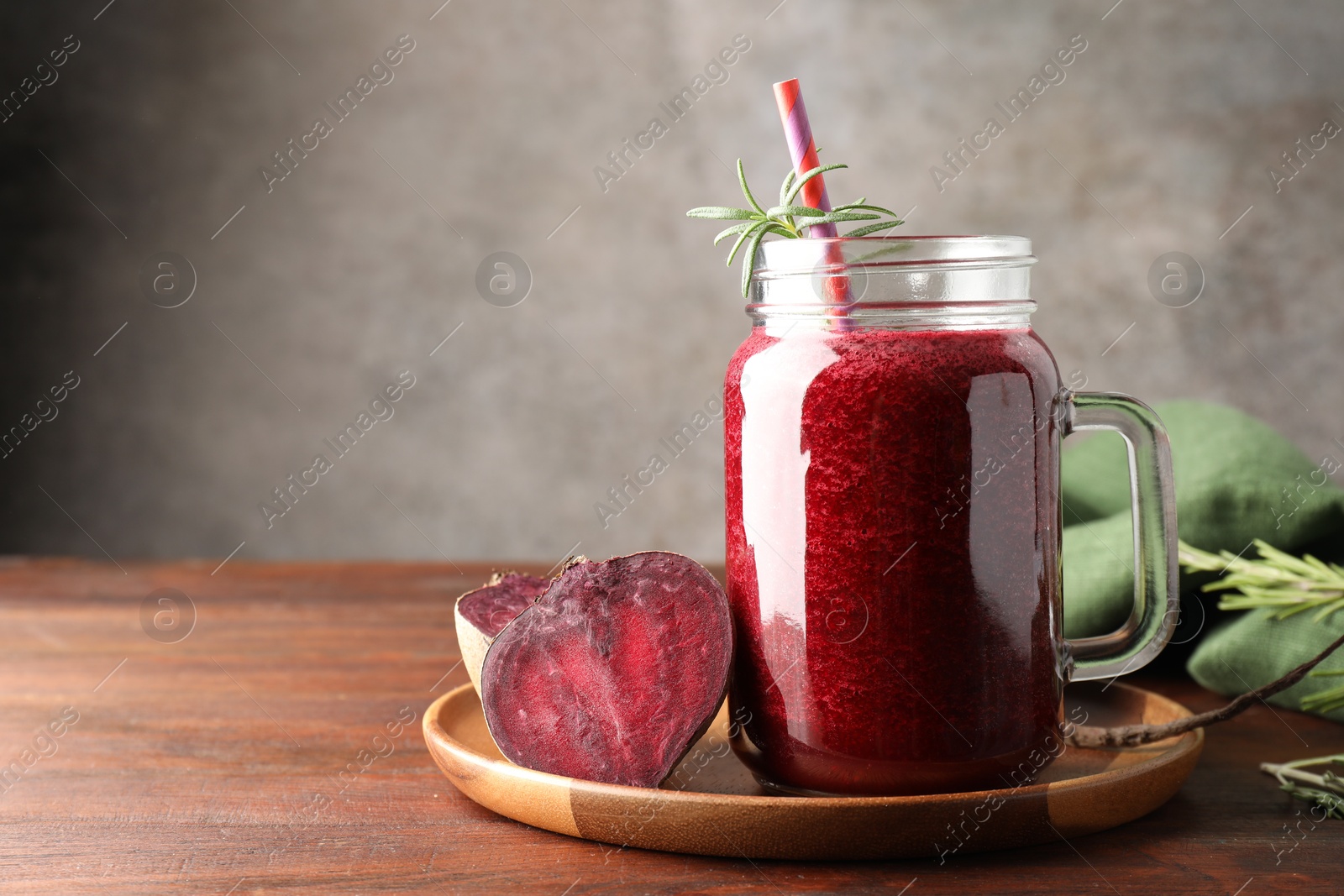 Photo of Fresh beetroot smoothie in mason jar and vegetables on wooden table, closeup. Space for text