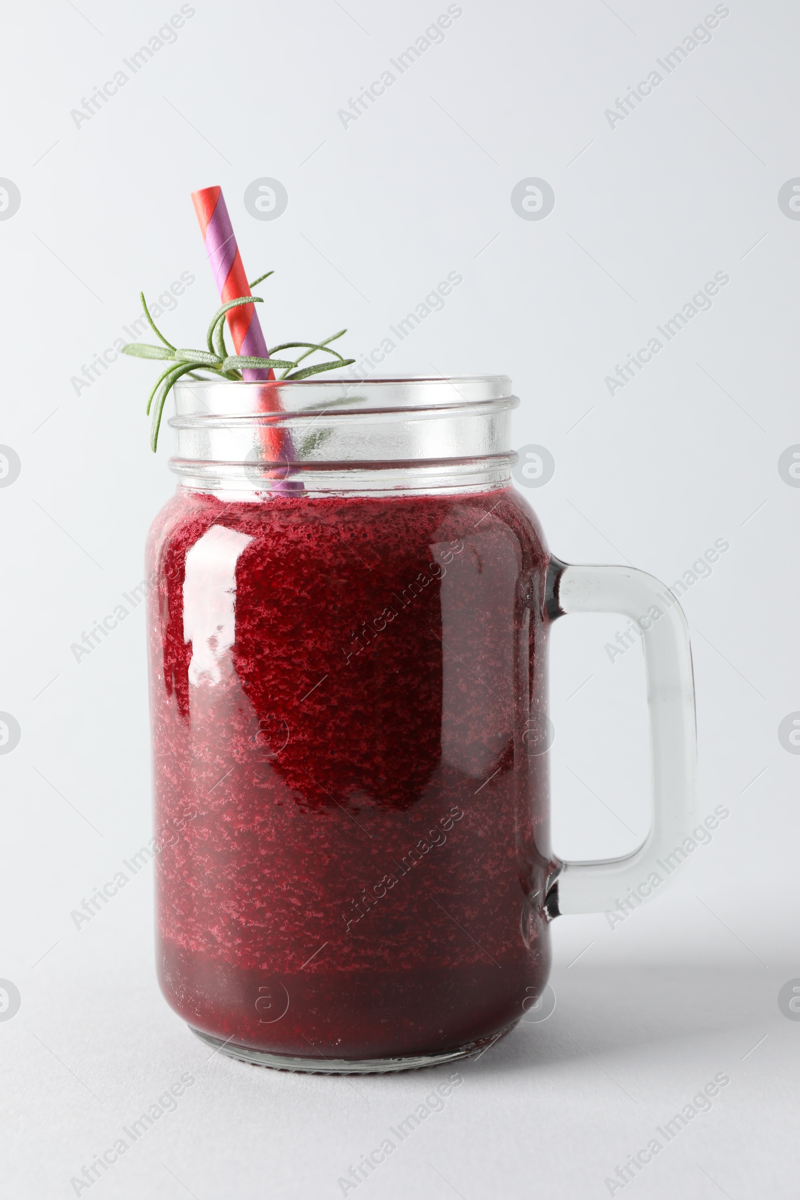 Photo of Fresh beetroot smoothie in mason jar on light background, closeup