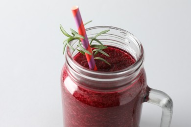 Photo of Fresh beetroot smoothie in mason jar on light background, closeup