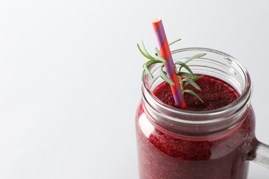 Photo of Fresh beetroot smoothie in mason jar on light background, closeup. Space for text