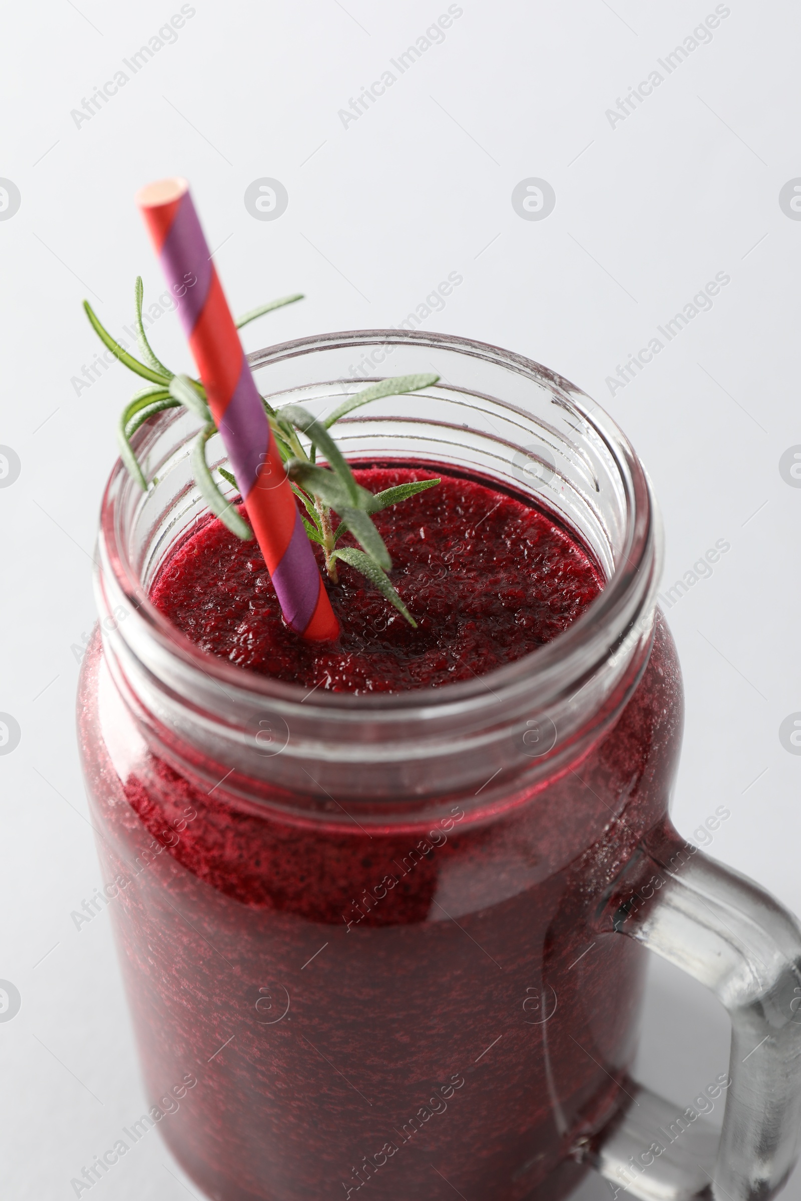 Photo of Fresh beetroot smoothie in mason jar on light background, closeup