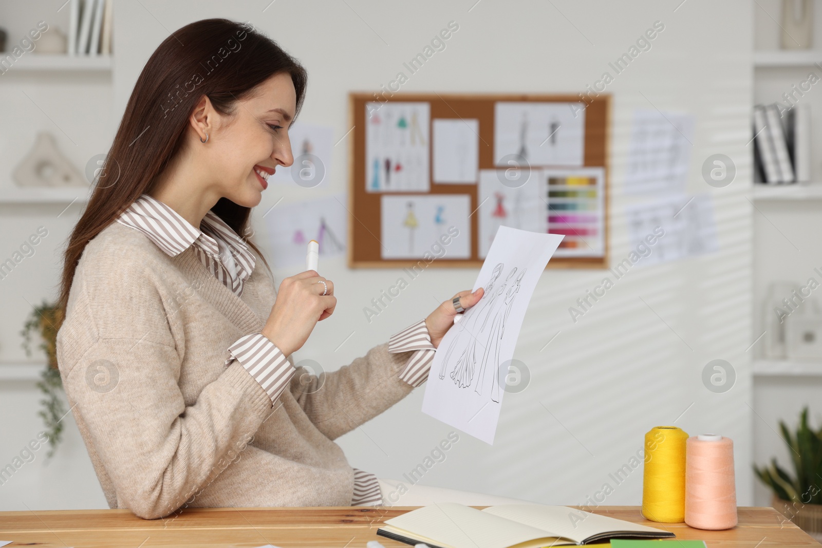 Photo of Fashion designer working at wooden table in workshop