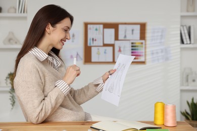 Fashion designer working at wooden table in workshop