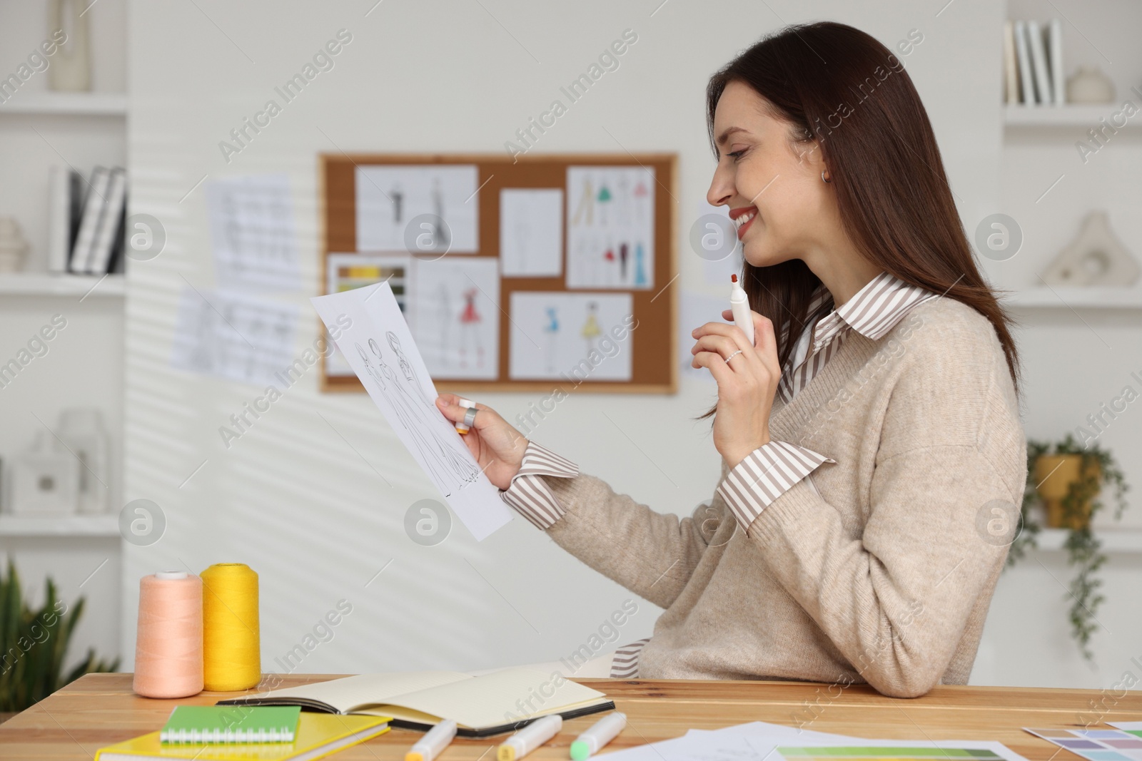 Photo of Fashion designer working at wooden table in workshop