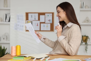 Fashion designer working at wooden table in workshop