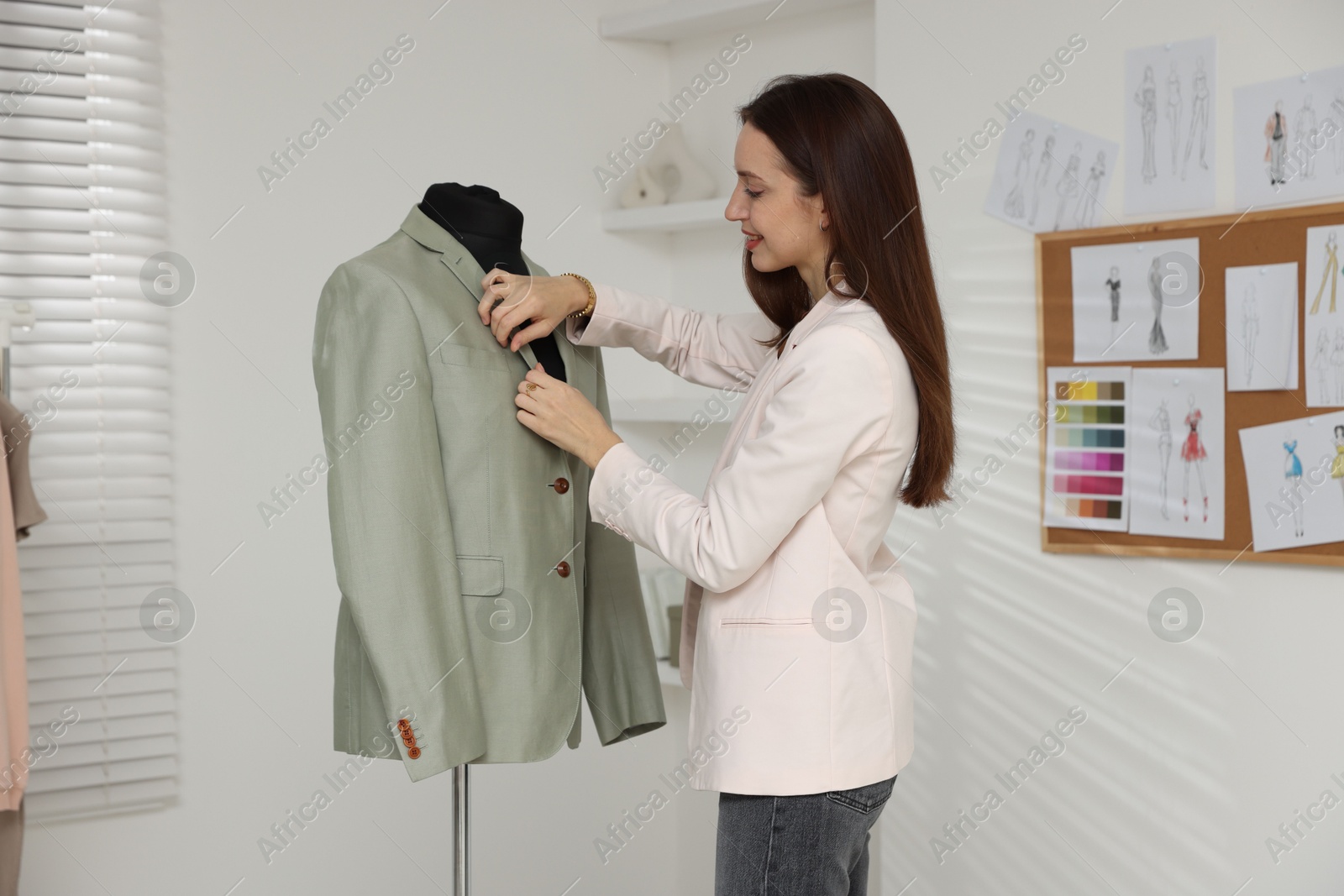 Photo of Fashion designer working with jacket in workshop