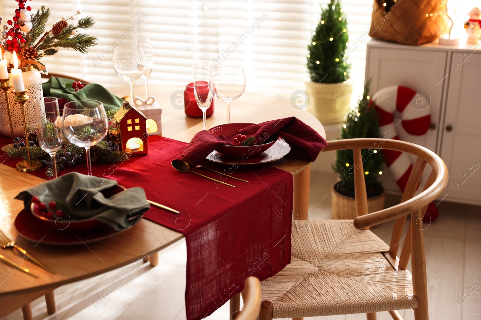 Photo of Christmas table setting with stylish dishware and festive decor indoors