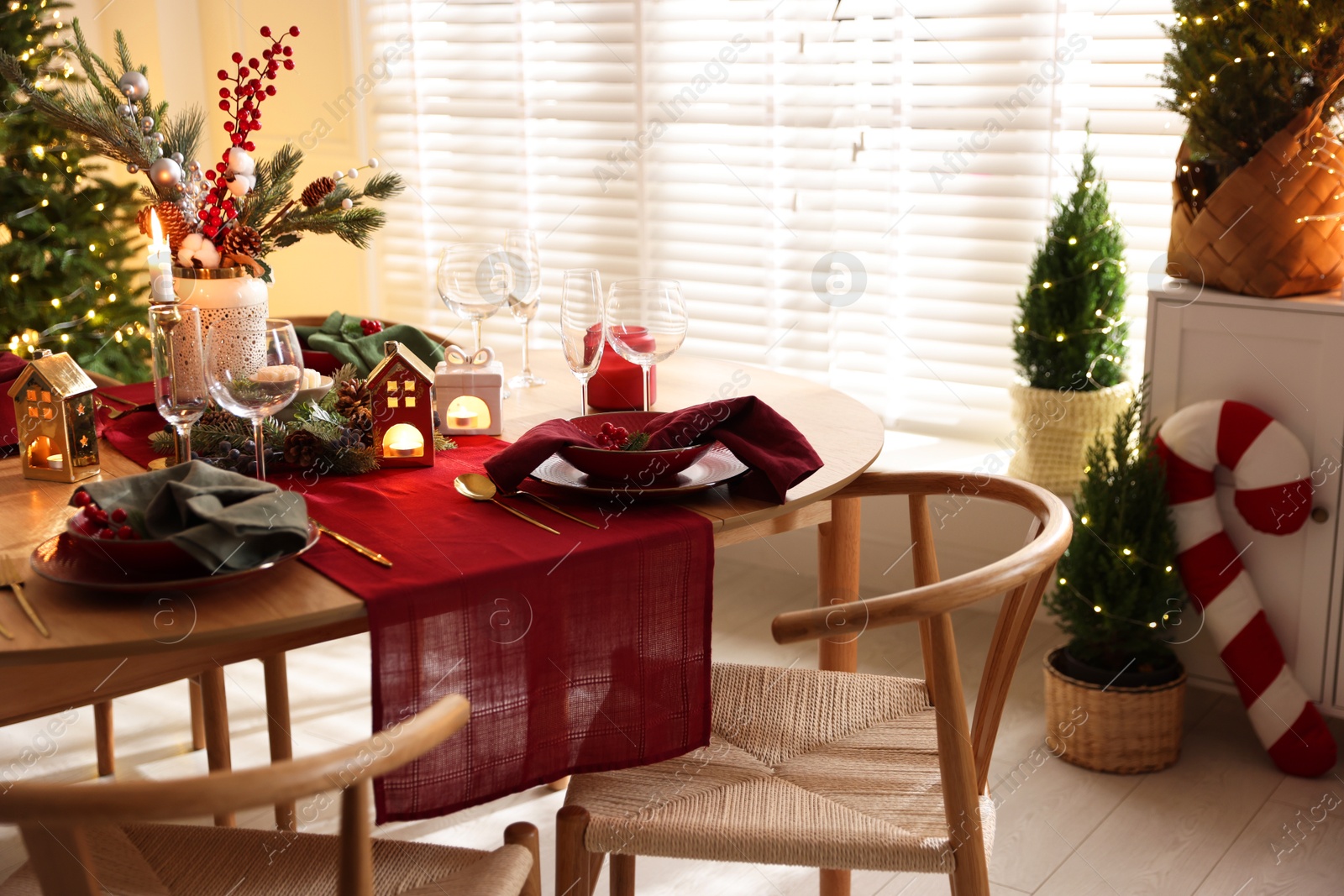 Photo of Christmas table setting with stylish dishware and festive decor indoors