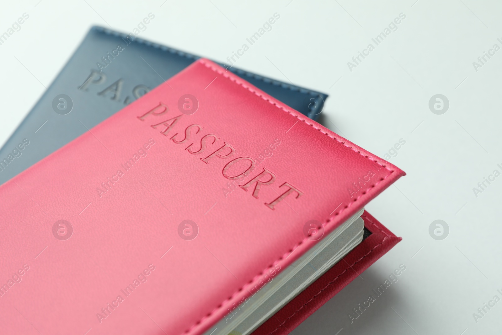 Photo of Passports in color covers on light background, closeup