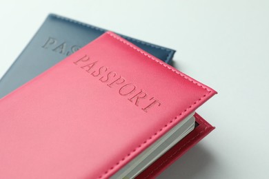 Photo of Passports in color covers on light background, closeup