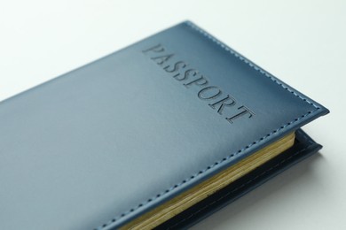 Photo of Passport in dark blue cover on light background, closeup