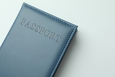 Photo of Passport in dark blue cover on light background, top view