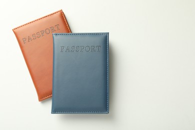 Photo of Passports in color covers on light background, top view. Space for text